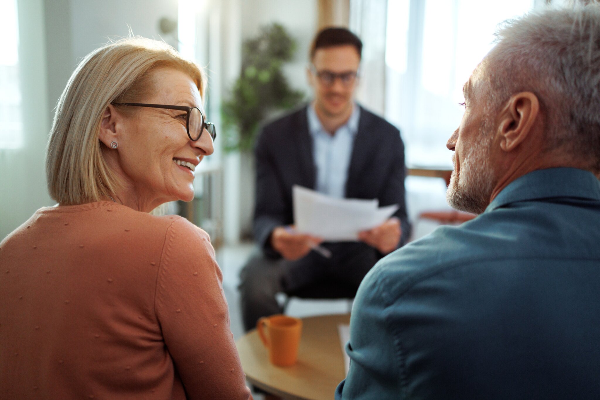 man and woman with financial advisor smiling.
